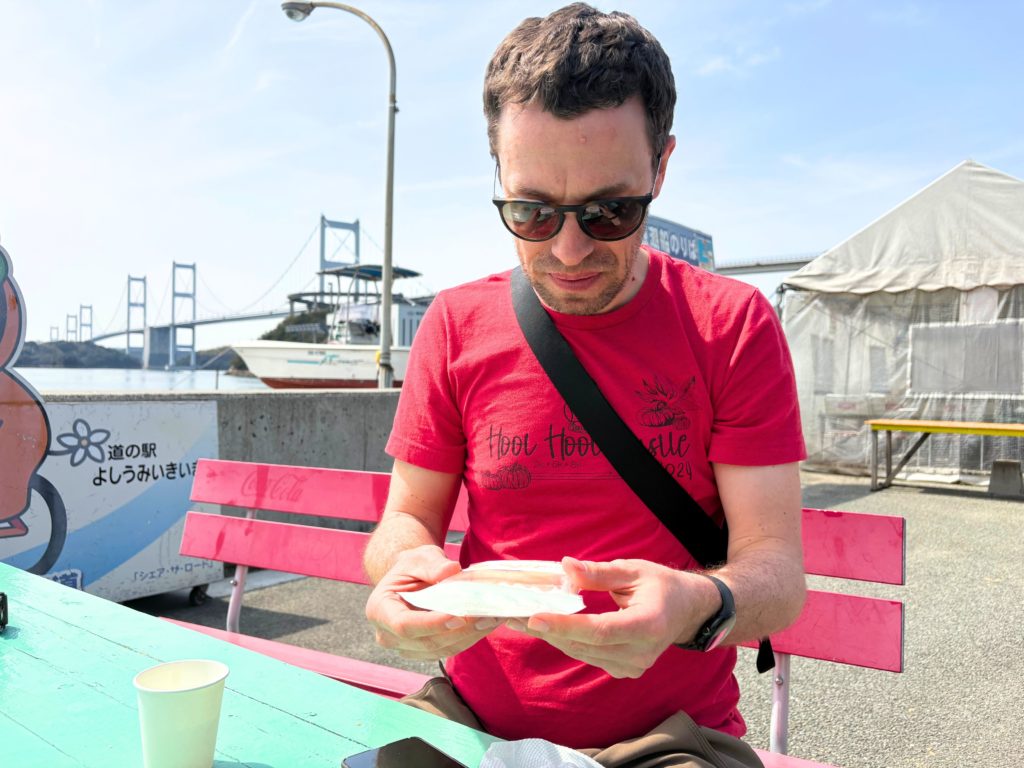 伊予柑ケーキを手に取って見つめる外国人