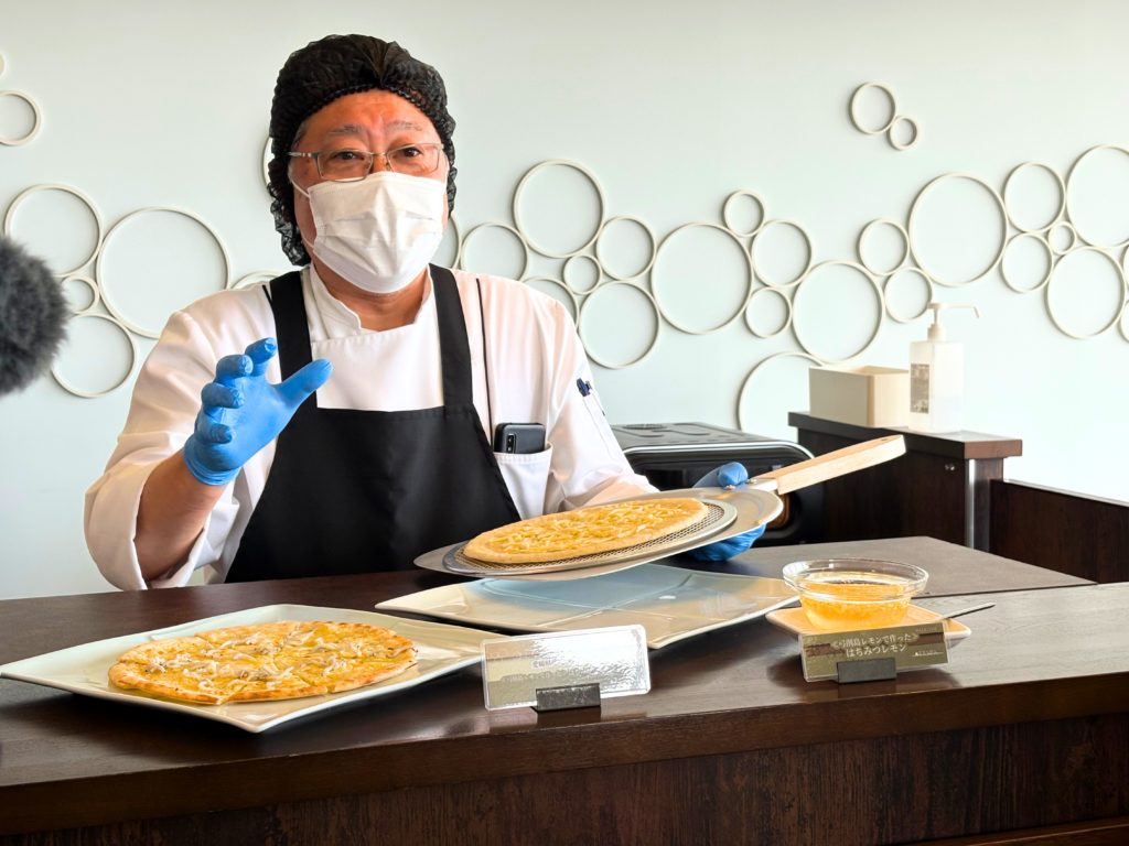 インランド・シー・リゾート・フェスタのバーエリアでピザの説明をするスタッフ