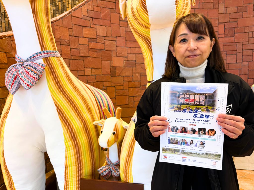 FABRIC SOUNDのチラシを持つタオル美術館館長の越智さん